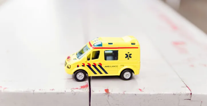 A toy ambulance on a bench