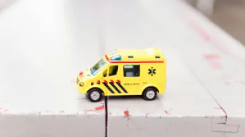 A toy ambulance on a bench