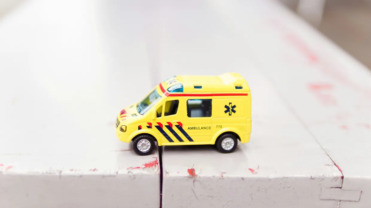 A toy ambulance on a bench